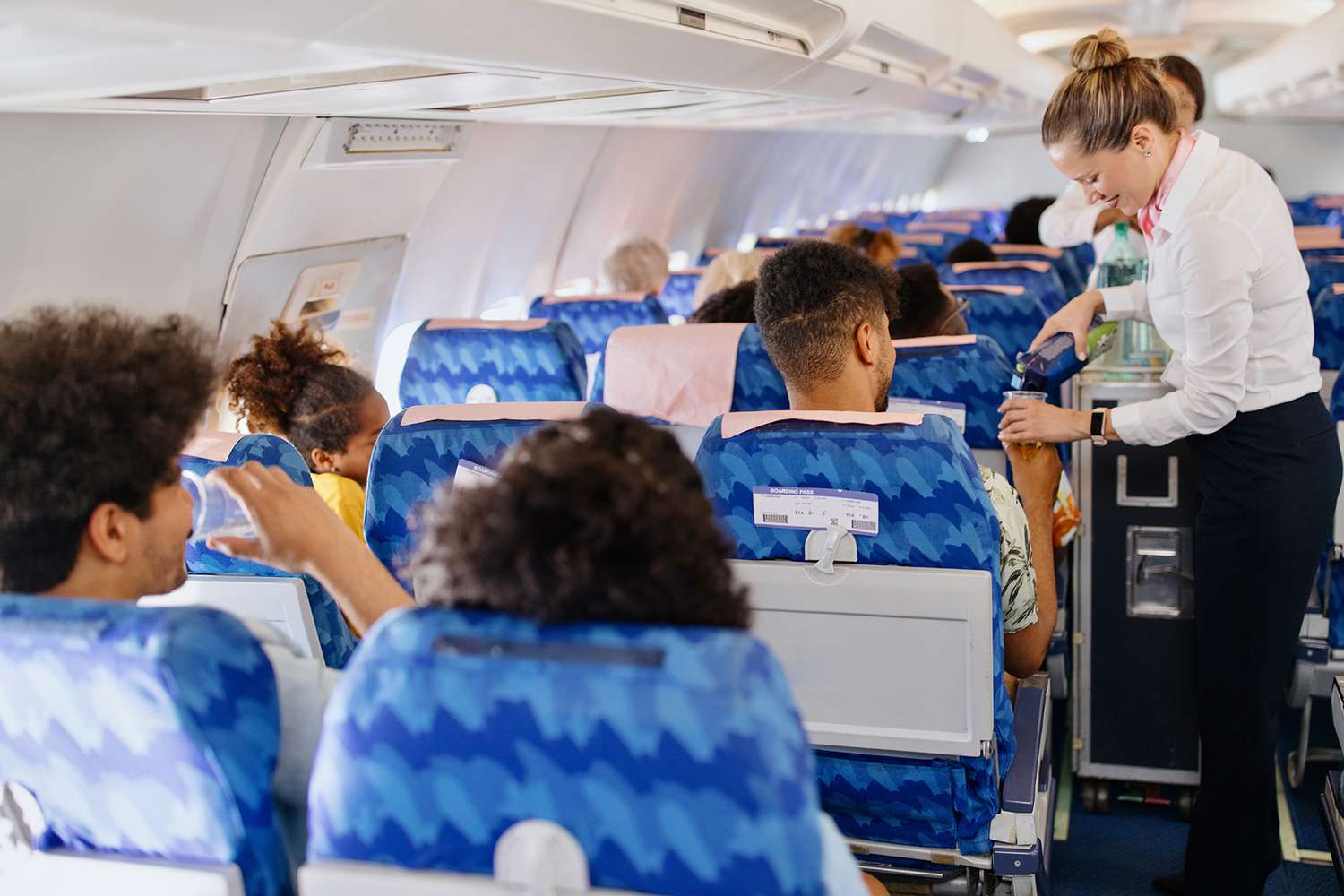 flight attendant pushing a drink cart